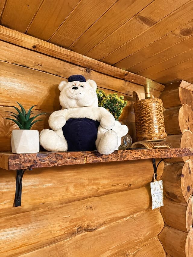 Decorative wooden shelf with a teddy bear in a villa bedroom